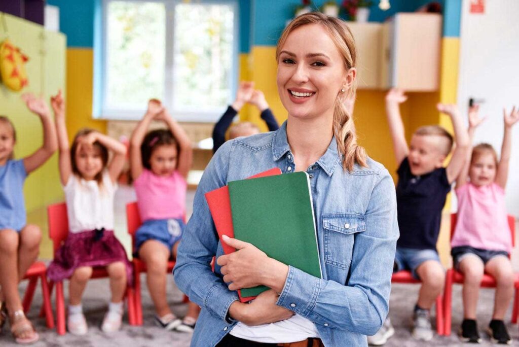 smiling teacher holding textbooks